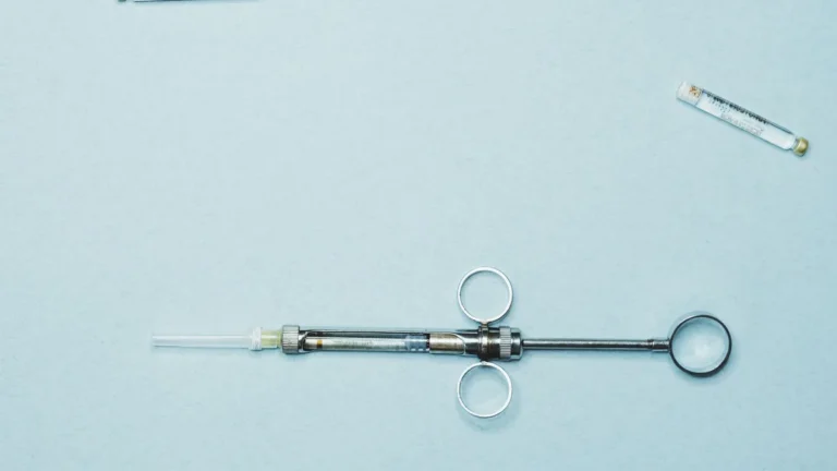 High-quality stock photo of a dental syringe and vials on a blue background. Ideal for dentistry.