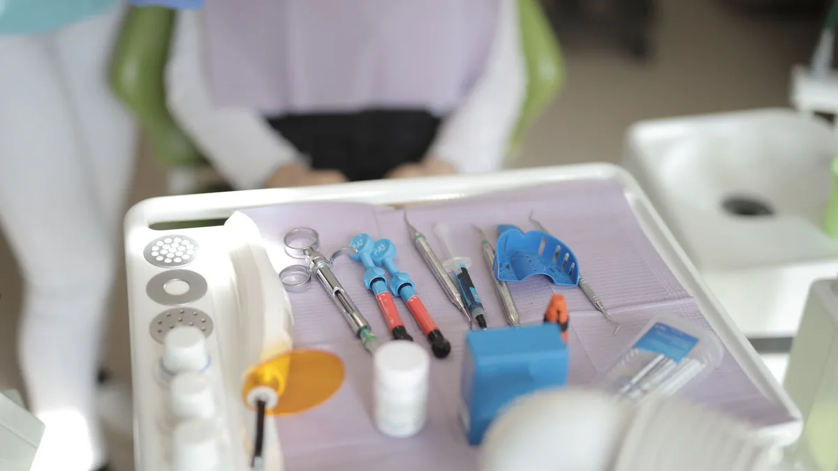 From above view of various modern medical instruments placed on tray near chair in modern room in clinic