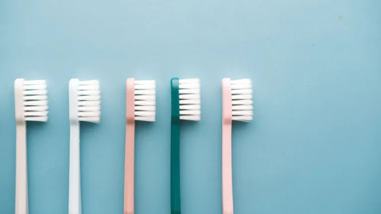 A row of five colorful toothbrushes arranged on a blue background, perfect for dental care themes.
