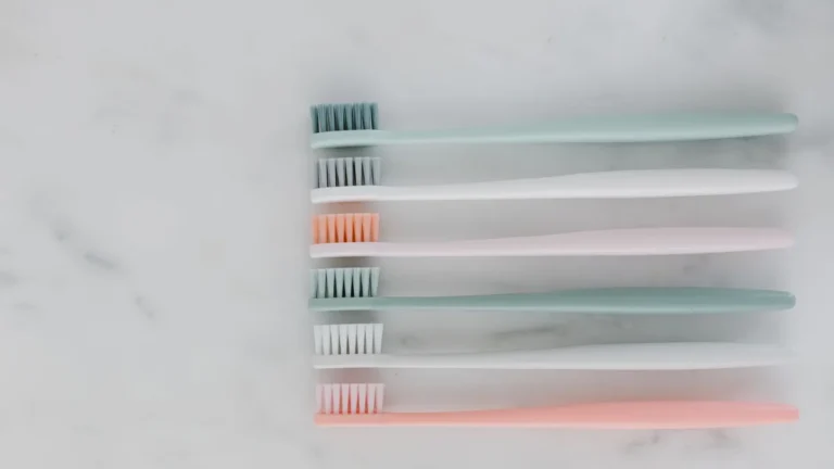 Minimalist arrangement of pastel toothbrushes on a marble surface, ideal for dental care themes.