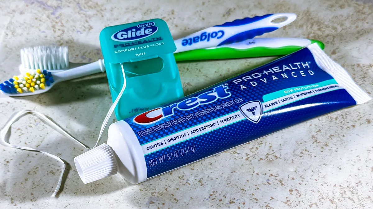 Close-up of dental care items including toothbrush, floss, and toothpaste for oral hygiene.