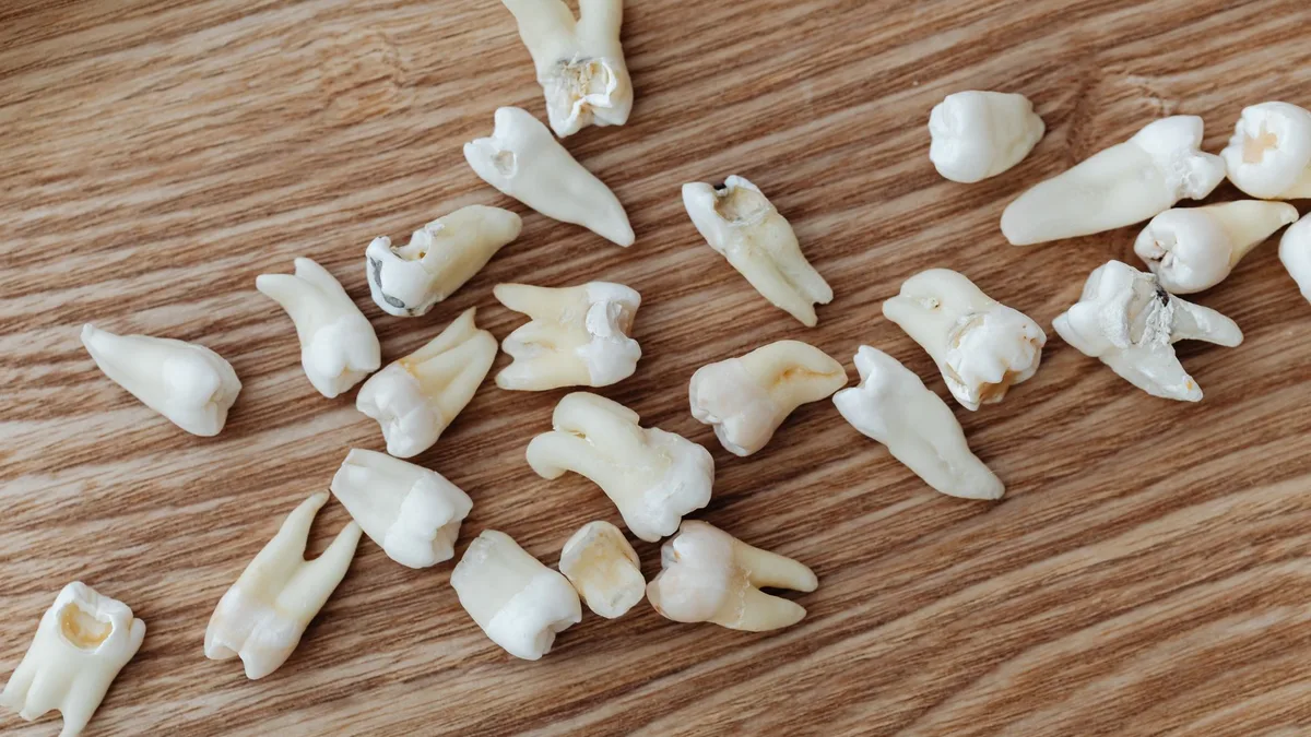 Close-up image of human teeth scattered on a wooden background, ideal for dental topics.