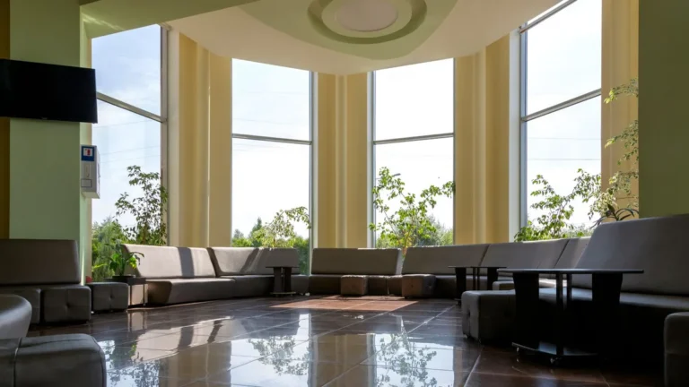 A spacious lobby with large windows, modern seating, and abundant natural light.