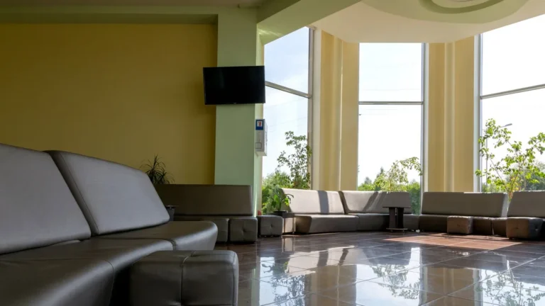 Spacious lobby with sleek furniture and large windows letting in bright daylight.