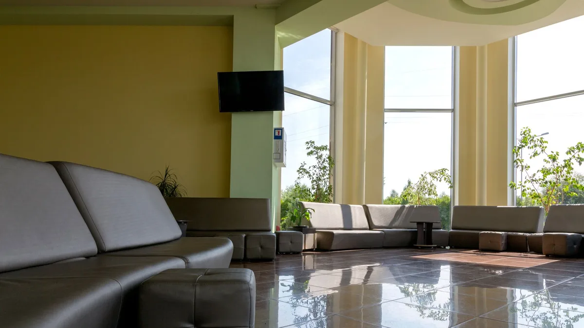 Spacious lobby with sleek furniture and large windows letting in bright daylight.