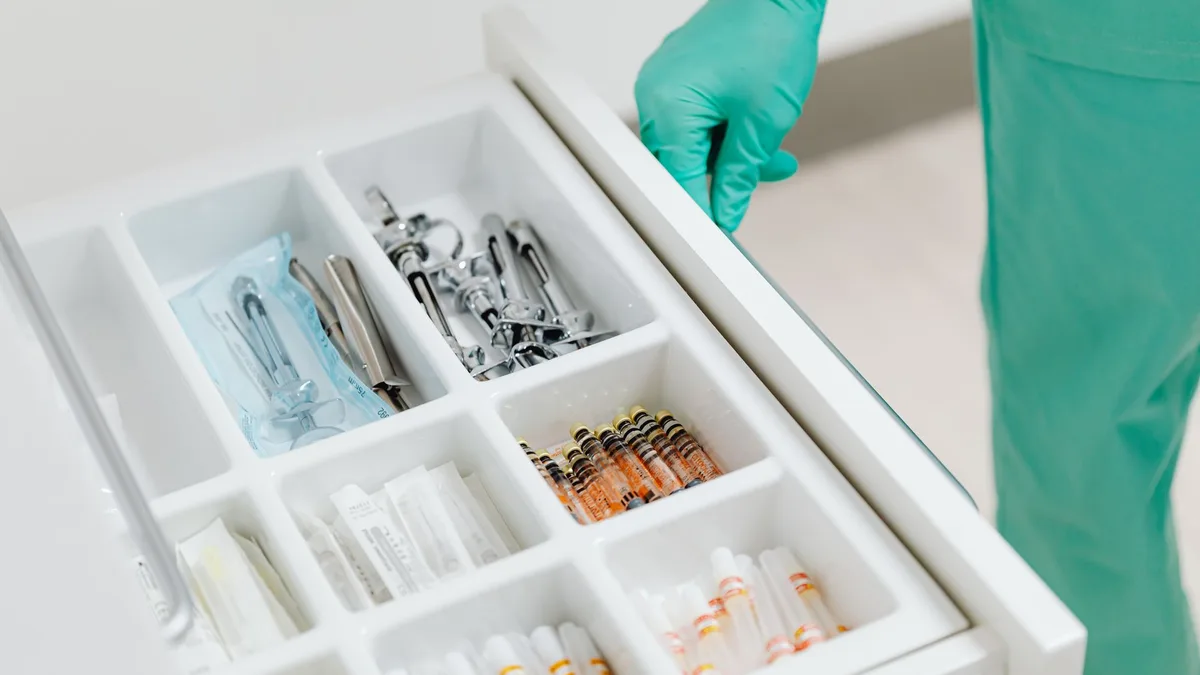 Sterile drawer with medical instruments and syringes in a clinic setting.