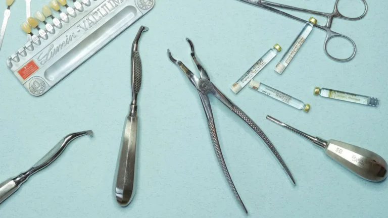 Overhead shot of various dental tools and materials arranged on a blue background.